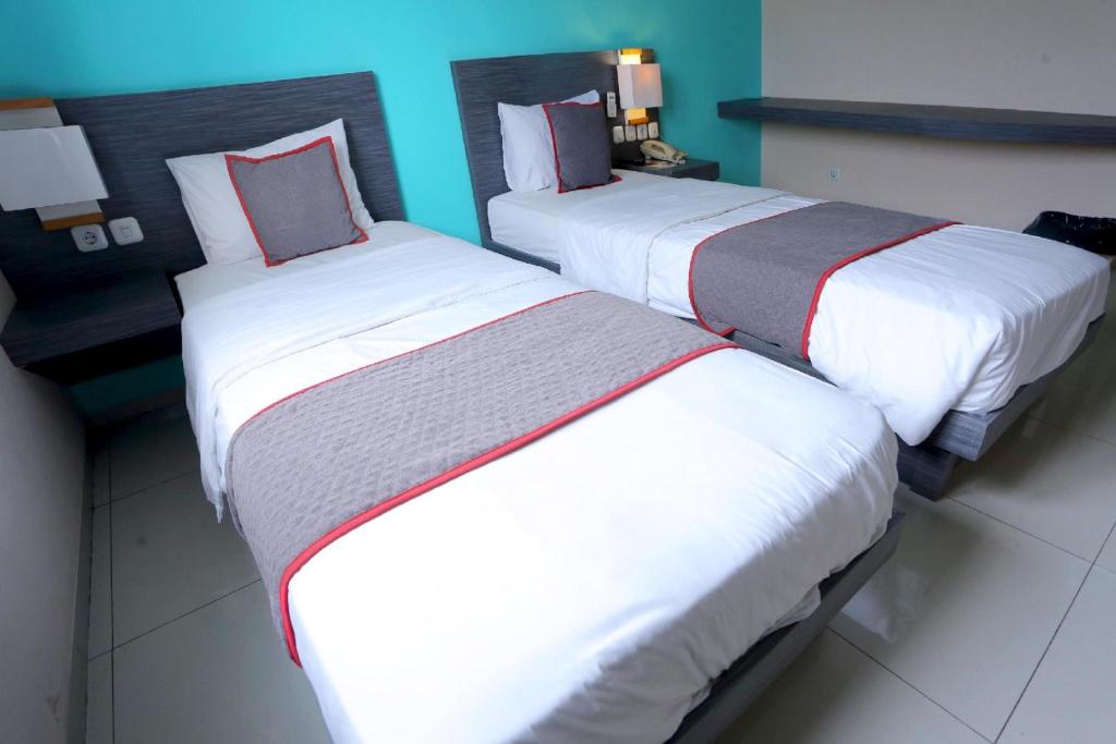 Postel nebo postele na pokoji v ubytování Super OYO Townhouse OAK Hotel Fiducia Pondok Gede