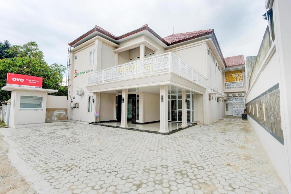 a house with a stone driveway in front of it at Hotel O Sukarame Near Imanuel Hospital Way Halim Formerly Hotel Griya Bawean in Bandar Lampung
