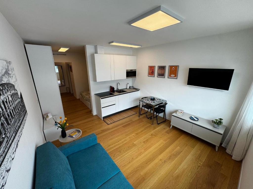 een woonkamer met een blauwe bank en een keuken bij GioLu Colosseo in Rome