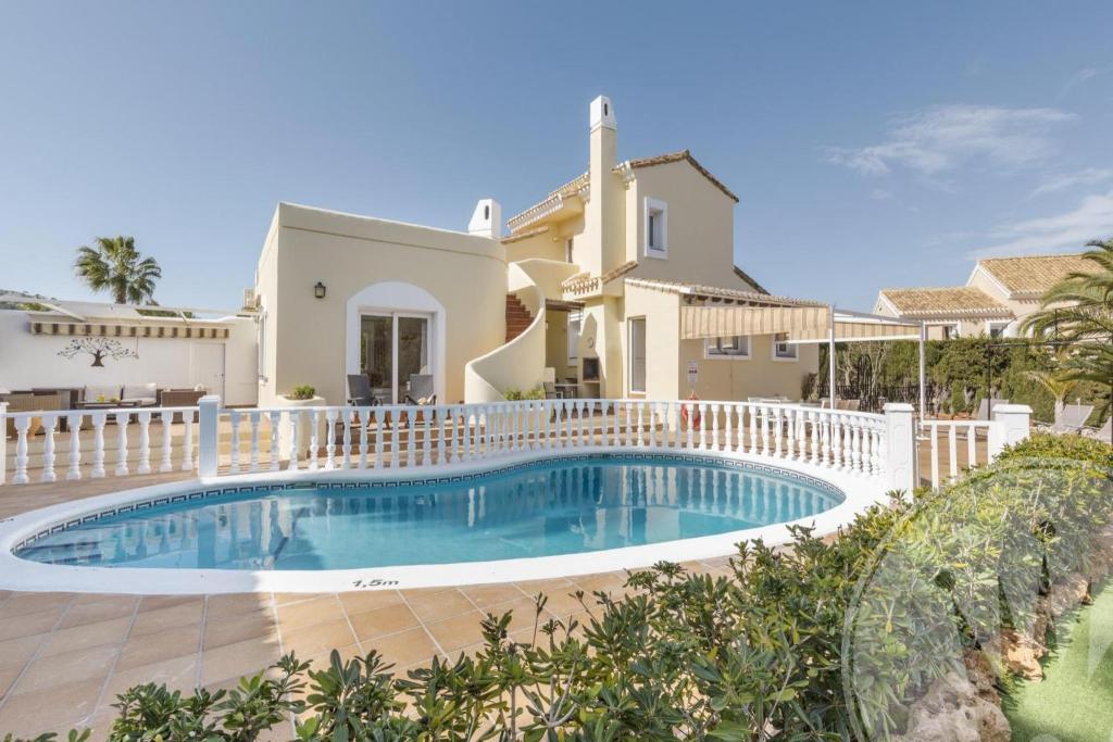 eine Villa mit einem Swimmingpool vor einem Haus in der Unterkunft Las Brisas 87 in Atamaría