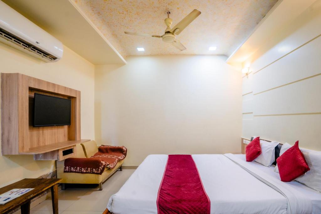 a bedroom with a bed and a tv and a couch at Mahadev Regency Hotel in Jaipur
