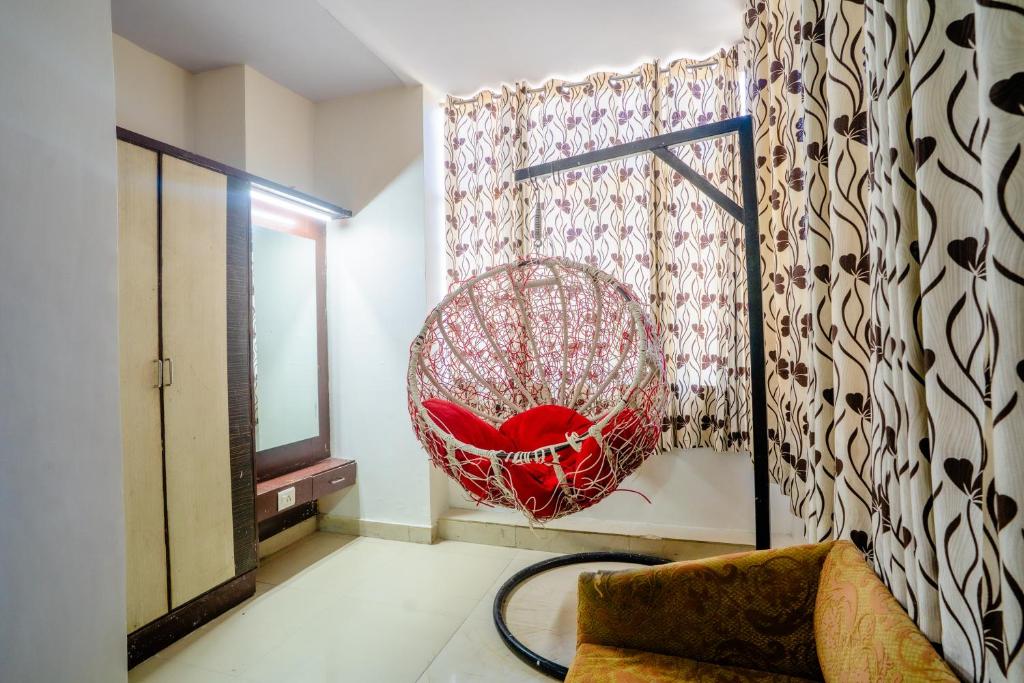 a room with a red chair and a window at Mahadev Regency Hotel in Jaipur