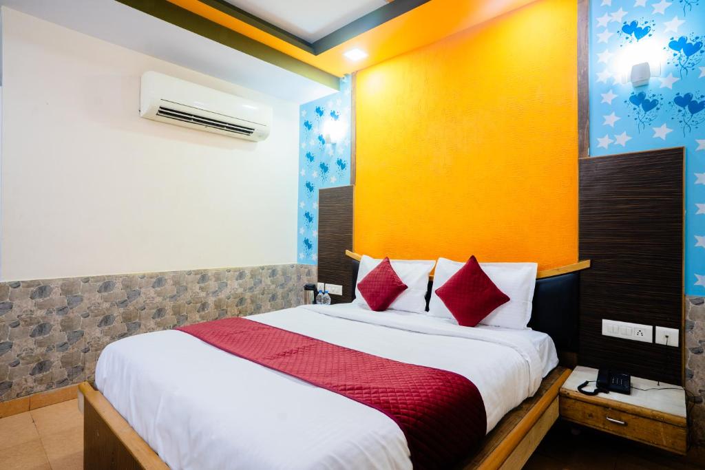 a bedroom with a large bed with red pillows at Mahadev Regency Hotel in Jaipur