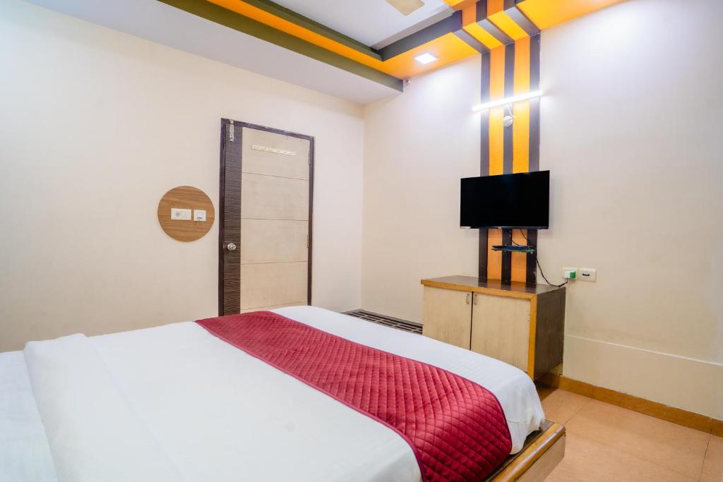 a bedroom with a bed and a television in it at Mahadev Regency Hotel in Jaipur