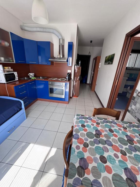 kuchnia z niebieskimi szafkami i stołem w pokoju w obiekcie AMA cityhouse w mieście Novara