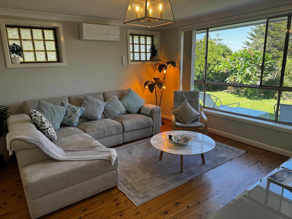 a living room with a couch and a table at Frogs by the Sea in Cronulla