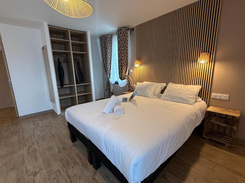 a bedroom with a large bed with white sheets at Appart hotel Marseille Aéroport in Vitrolles