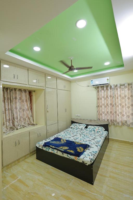 a bedroom with a bed and a ceiling at Bhakti Bliss Homestay - 2BHK modern Apartment with AC, Wifi and Android TV in Tirupati