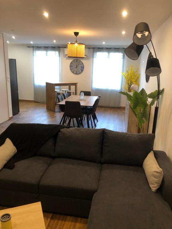 a living room with a couch and a dining room at APPARTEMENT F3 BOX Vélo Moto Centre historique in Mirepoix
