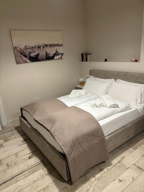 een slaapkamer met een groot bed met witte lakens bij Appartamento con patio in Monopoli
