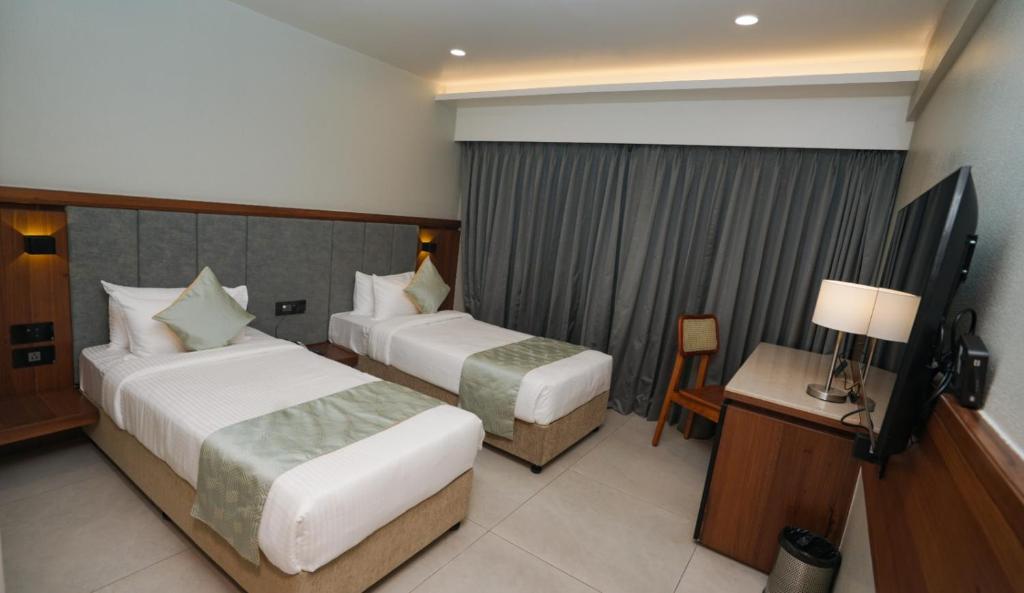 Postel nebo postele na pokoji v ubytování The Qubice Hotel, Kolhapur