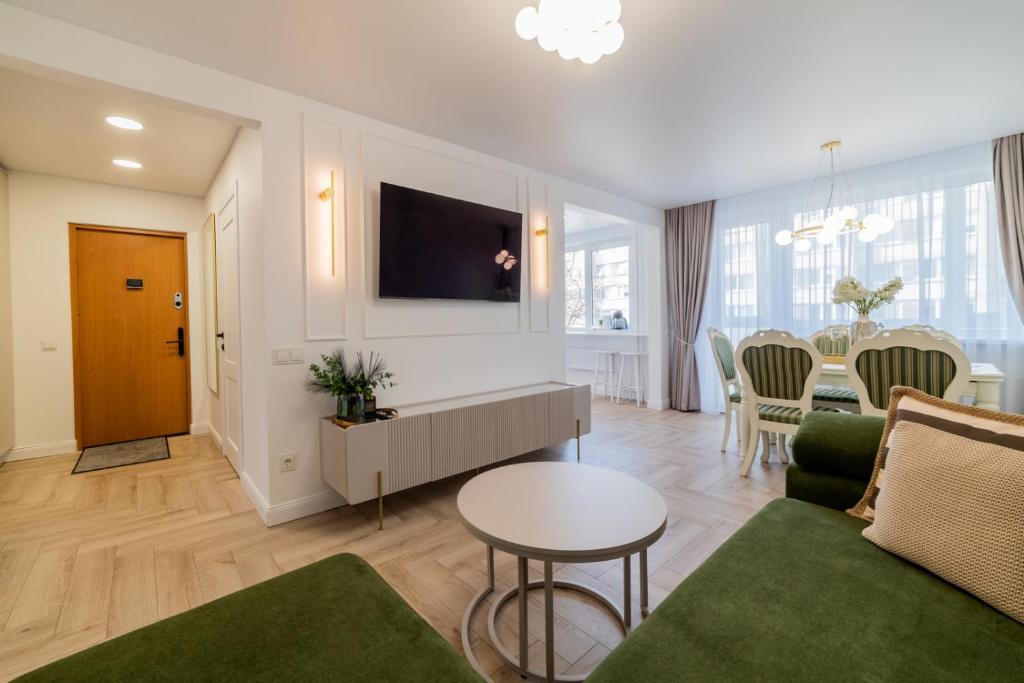 een woonkamer met een bank en een tafel bij Frida Luxury Apartments in Šiauliai