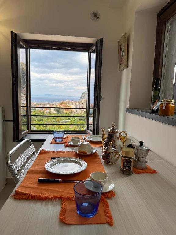 a dining room table with a view of a window at Sea View Loft Meta Sorrento Coast Free Parking in Meta