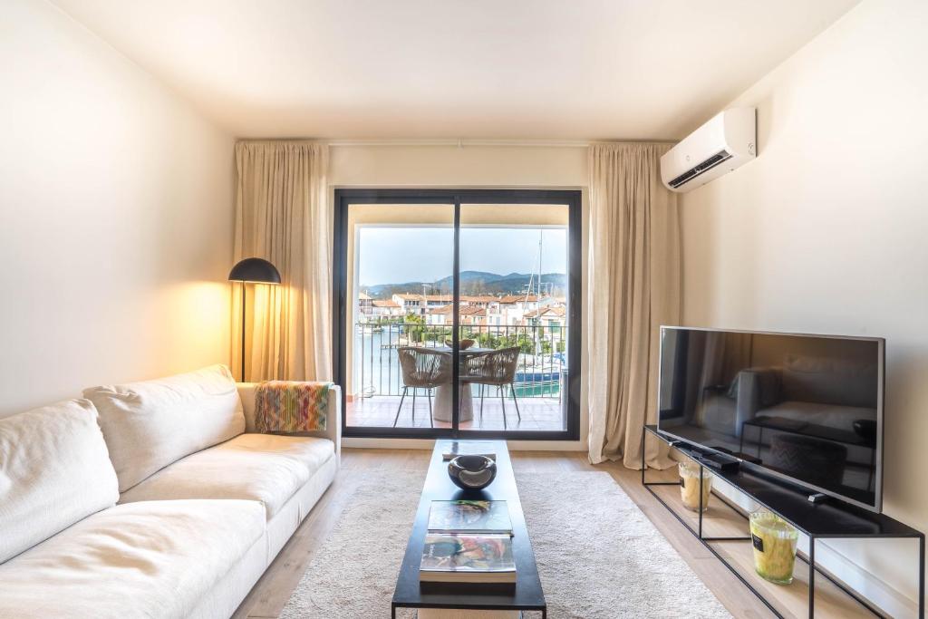 - un salon avec un canapé et une grande télévision dans l'établissement Appartement Port Grimaud, à Grimaud
