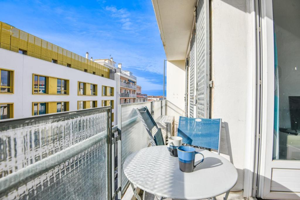 - une table sur un balcon avec une tasse de café dans l'établissement Appart 3 ch avec balcon à la Joliette, à Marseille