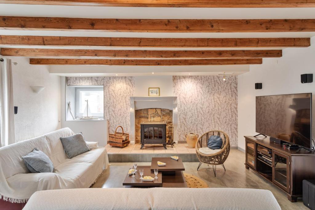 a living room with a white couch and a fireplace at Le Jardin d'Armor - Grand jardin parking privé in Lamballe