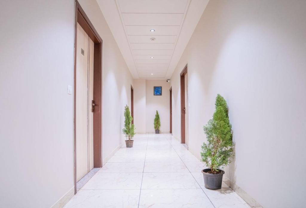 an empty corridor in an office building with potted plants at HOTEL SNOOZE in Jaipur