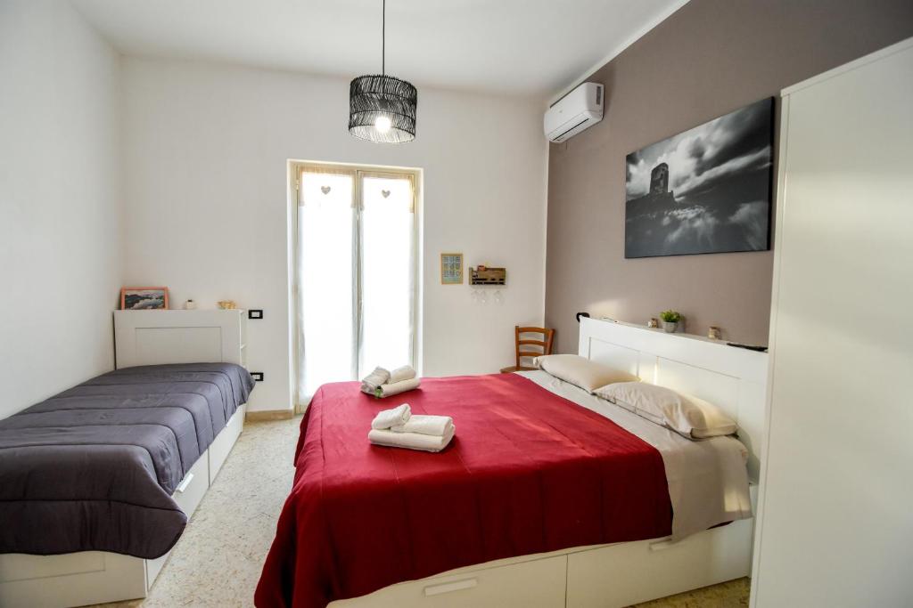 a bedroom with two beds and a red blanket at La Casetta sul Mare in Isola delle Femmine