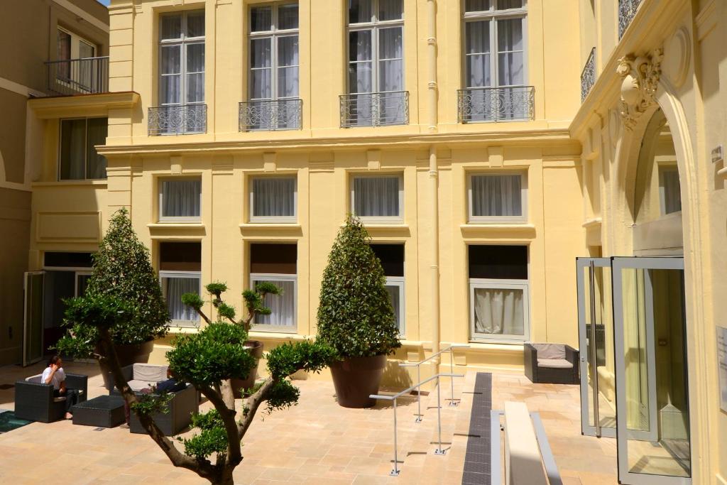 a yellow building with trees in front of it at Odalys City Montpellier Les Occitanes in Montpellier