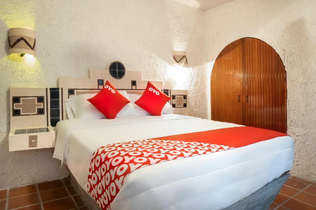 a bedroom with a large bed with red pillows at OYO Posada Astrud,Cuetzalan in Cuetzalán del Progreso
