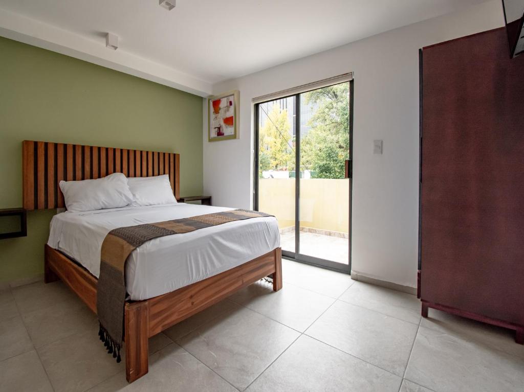 a bedroom with a bed and a large window at Collection O Hotel Lavanda Anzures in Mexico City