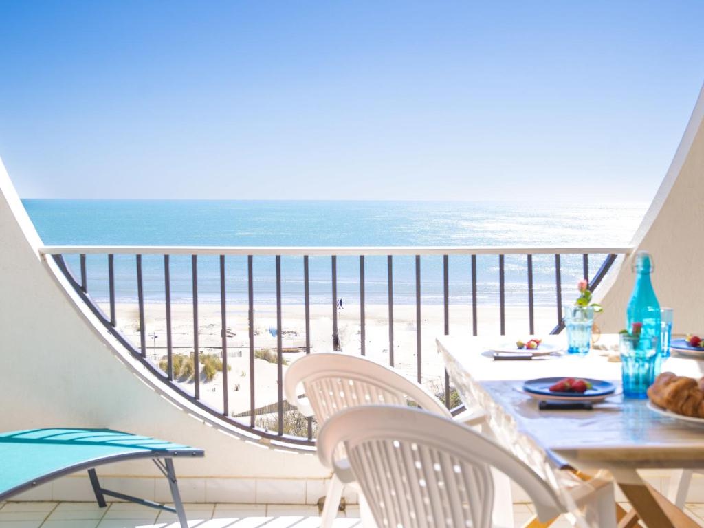 - un balcon avec une table et des chaises et la plage dans l'établissement Apartment Poséidon by Interhome, à La Grande Motte
