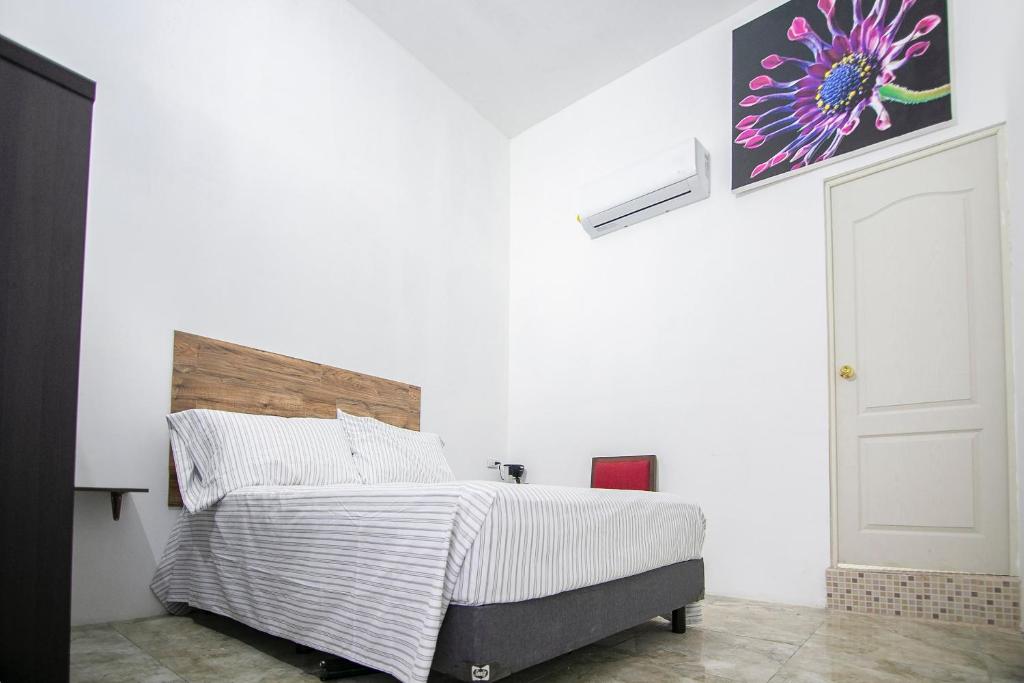a bedroom with a bed and a painting on the wall at OYO Hotel Plaza Las Torres, Cabo San Lucas in Cabo San Lucas