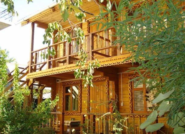 a large wooden house with a balcony on it at Svetlana in Lazarevskoye
