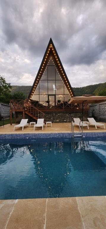 a swimming pool with chairs and a large building at Holiday Home in Vǝndam