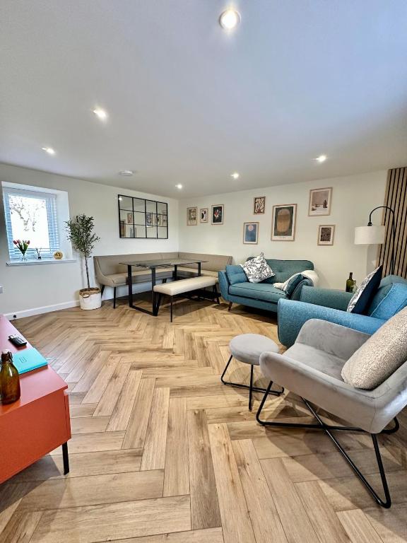 a living room with blue couches and wooden floors at Luxury Coastal Cottage in Portsoy