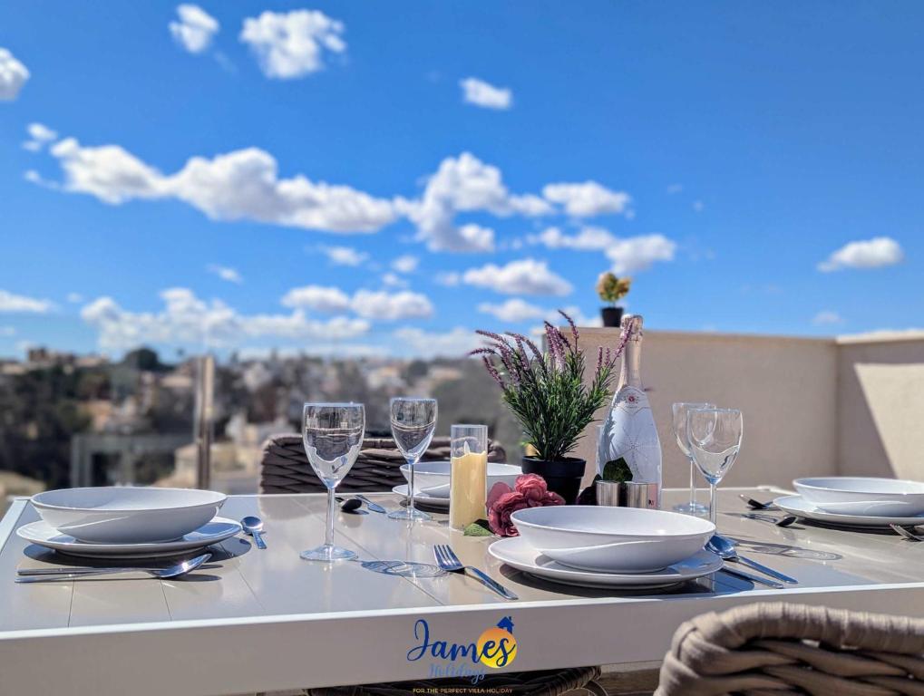 a table with plates and wine glasses on a balcony at Luxury penthouse with Solarium and Com Pool VM78 in Villamartin