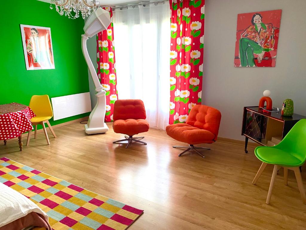 - un salon avec deux chaises et un mur vert dans l'établissement Chez mamie Rose wifi gratuit, à Bourges