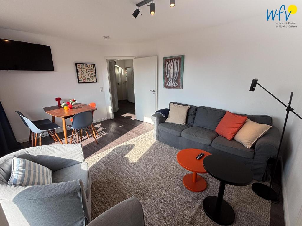 un salon avec un canapé et une table dans l'établissement Haus Nordstern Ferienwohnung Hummerhütte, à Juist