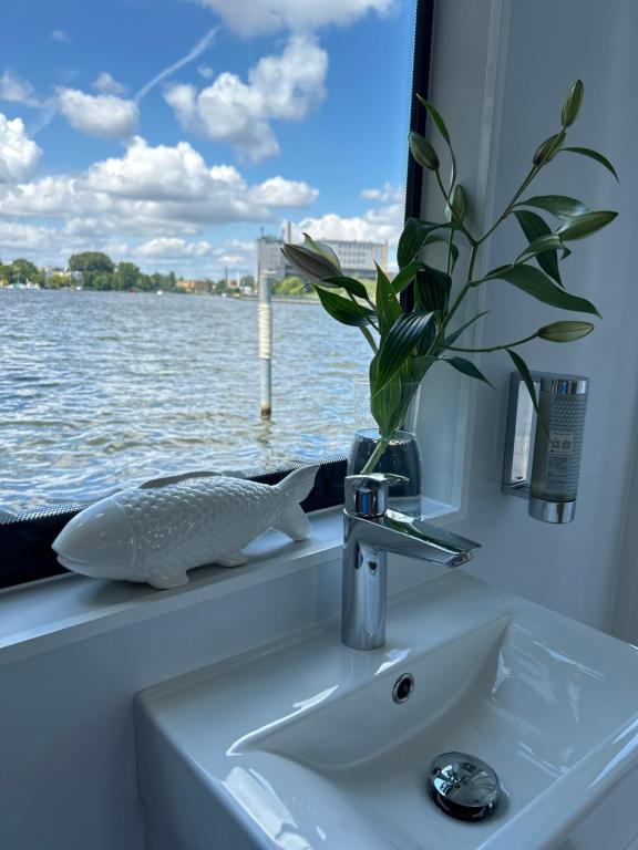 a bathroom sink with a potted plant next to a window at Nena Hausboot in Berlin