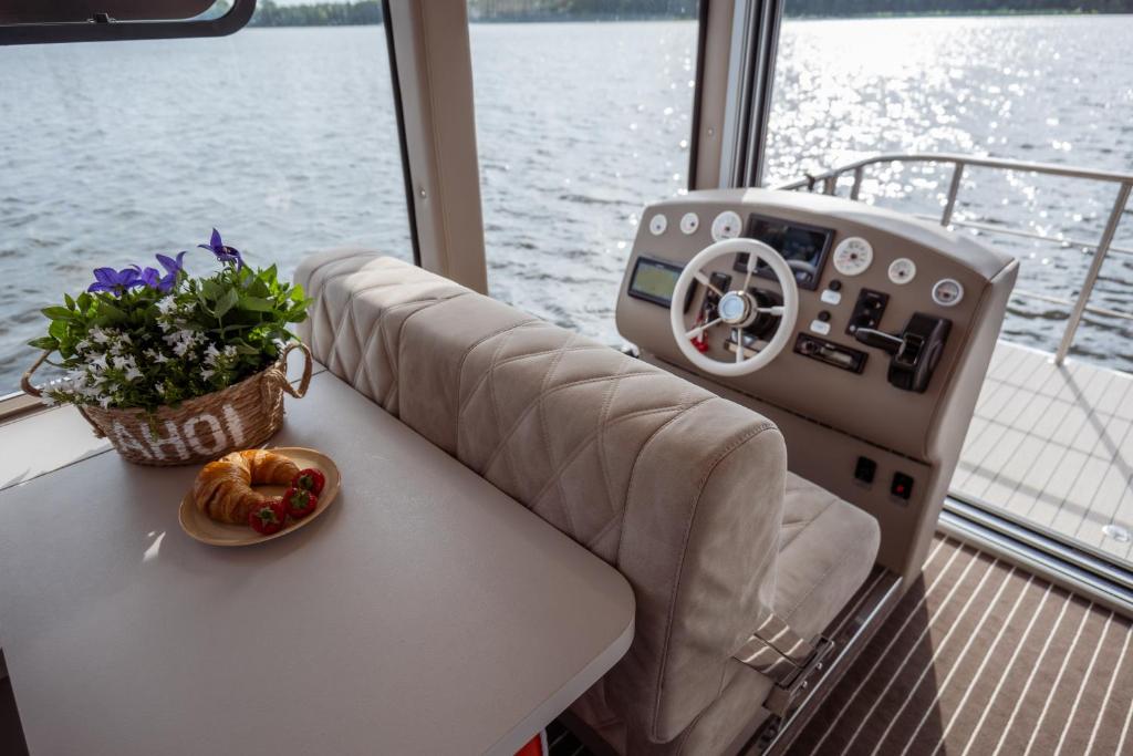 a table on a boat with a bowl of flowers on it at Nena Hausboot in Berlin