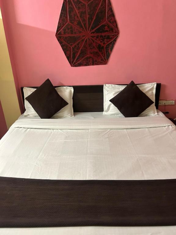 AkoliaHotel Decision的一张配有黑白枕头的床和粉红色的墙壁