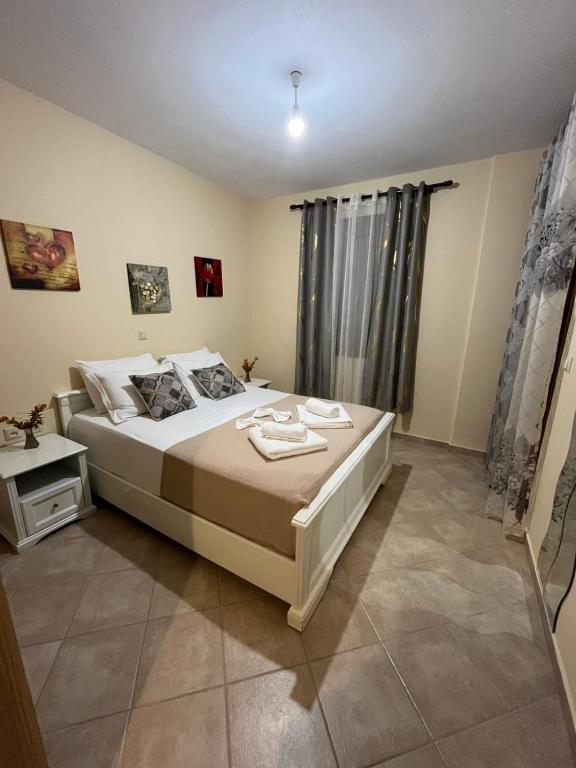 Un dormitorio con una cama grande y una ventana. en Melas Sweet Home, en Sivota