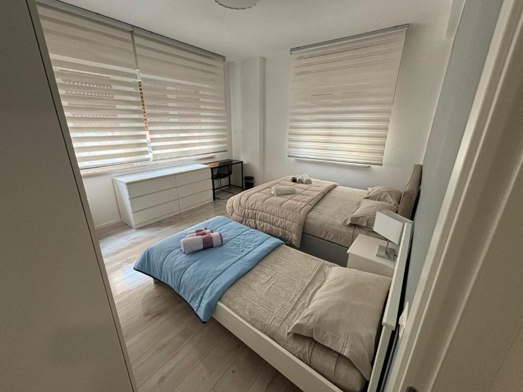 una camera con due letti e una finestra con persiane di Apartment -B by Homes in Ancona ad Ancona