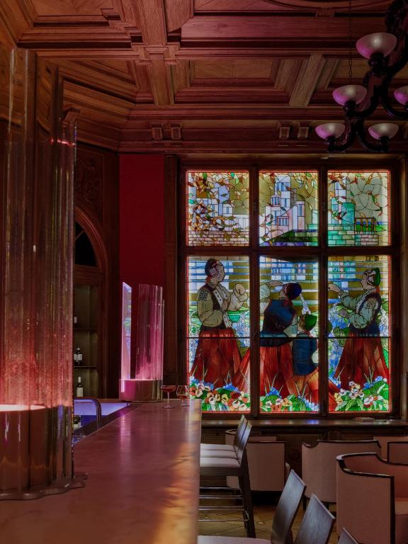 a large stained glass window in a room with chairs at The Benjamin House in Rīga