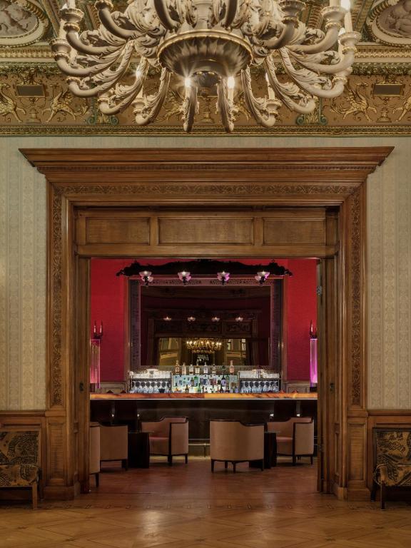 a bar in a red room with a chandelier at The Benjamin House in Rīga