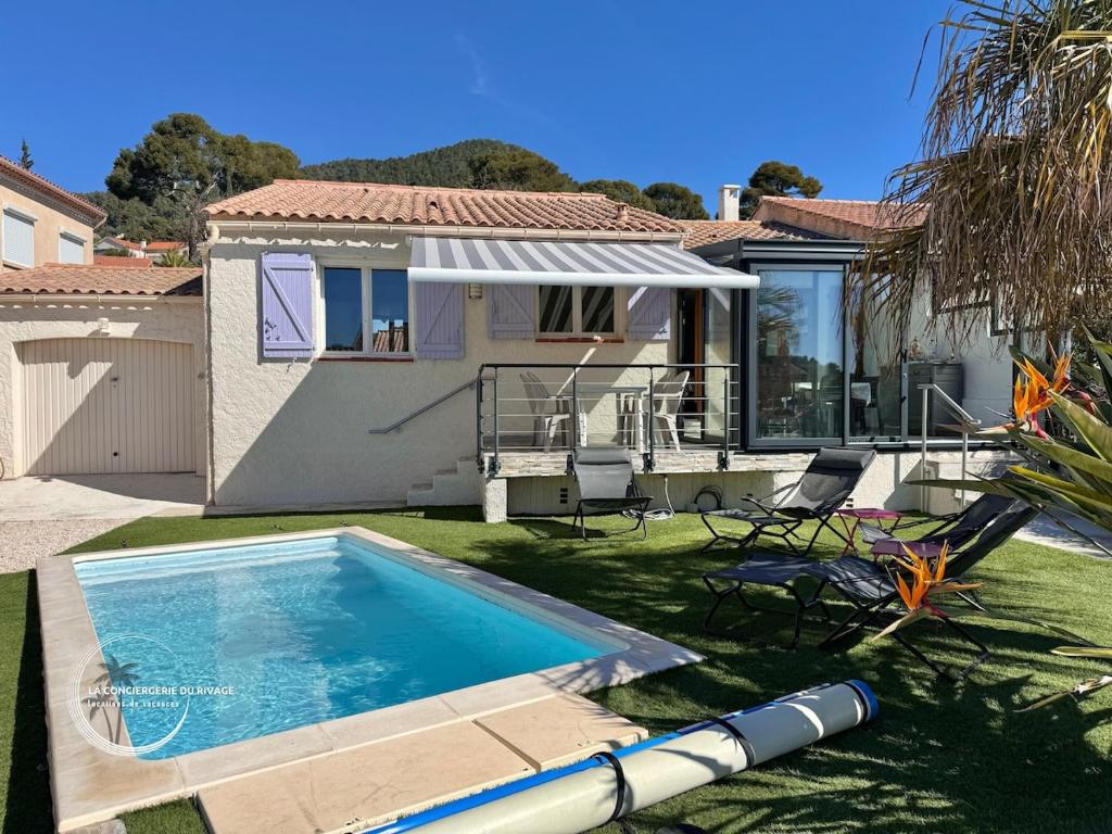 une piscine dans la cour d'une maison dans l'établissement Villa Les Vignes du Paradis - Piscine - Jardin, à Carqueiranne