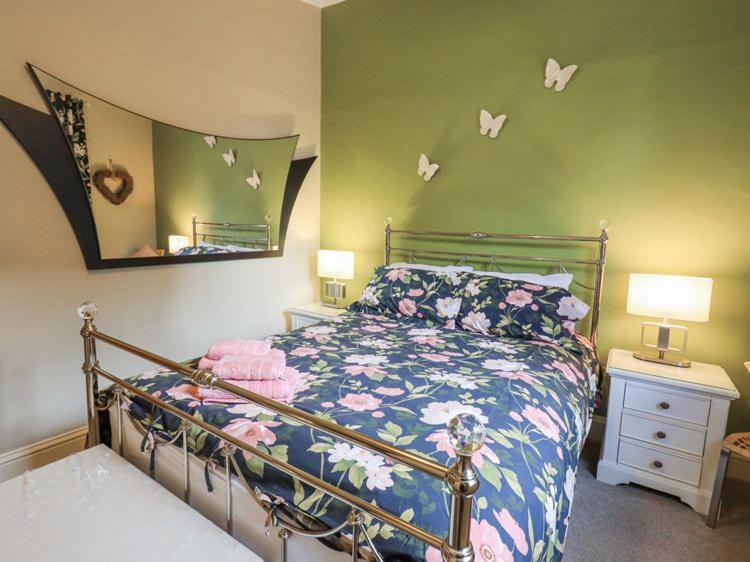 ein Schlafzimmer mit einem Bett und einem Spiegel in der Unterkunft Stylish & Contemporary 5 * Fully Renovated Luxurious Holiday Cottage Ambleside in Ambleside