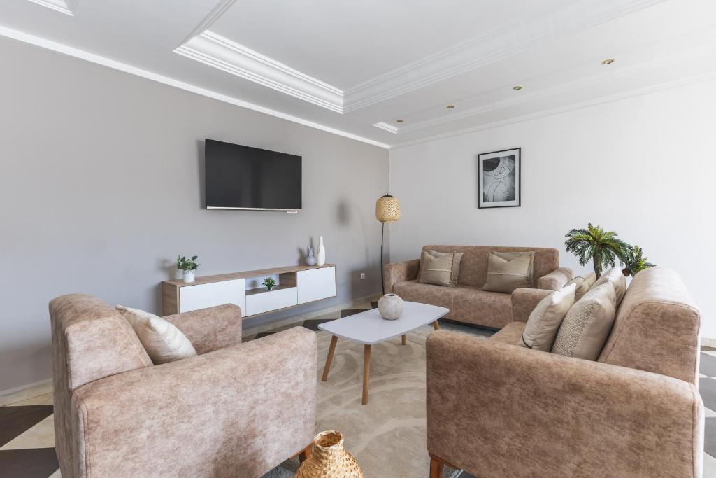 a living room with two couches and a tv at Appartement 4 pièces à Bir Mourad in Birmandreis