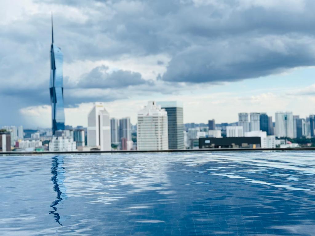 ein Blick auf die Stadt von einem Swimmingpool mit einer Skyline der Stadt in der Unterkunft XING LUN KLCC The Colony Infinitum in Kuala Lumpur