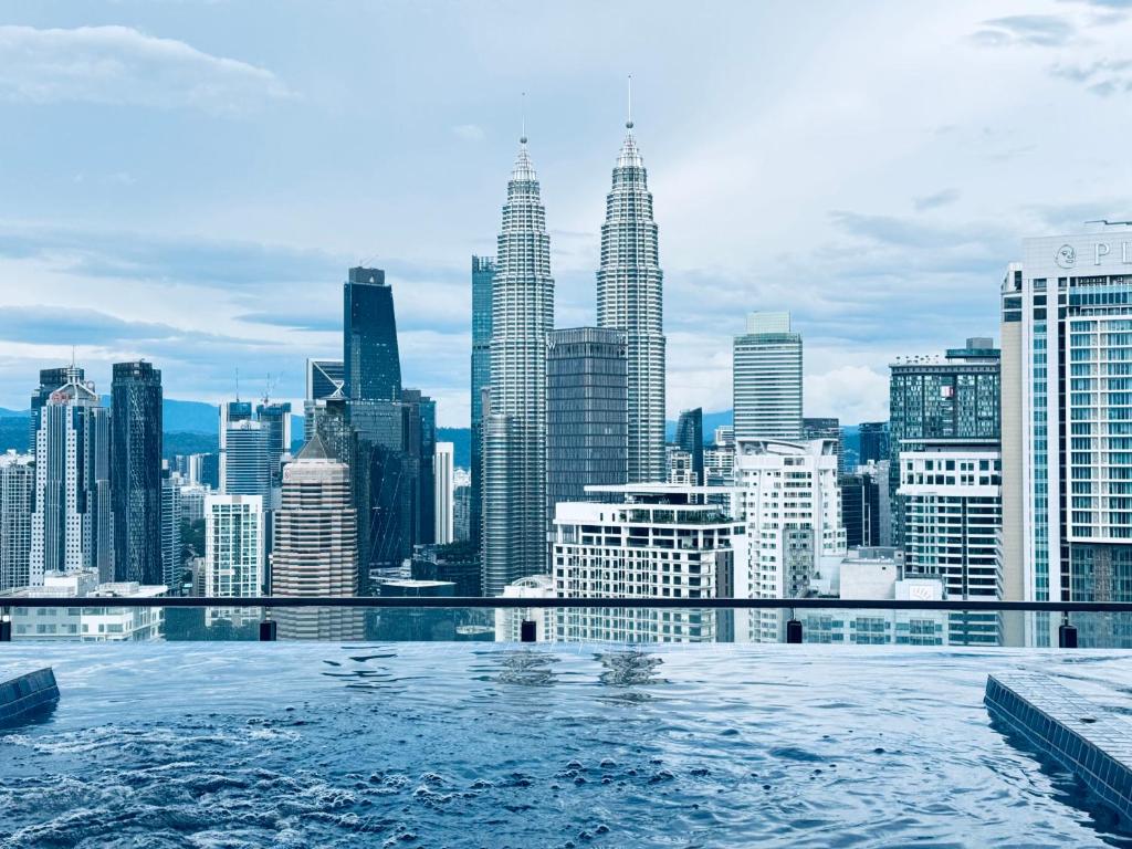 einen Pool mit Blick auf die Skyline der Stadt in der Unterkunft XING LUN KLCC The Colony Infinitum in Kuala Lumpur