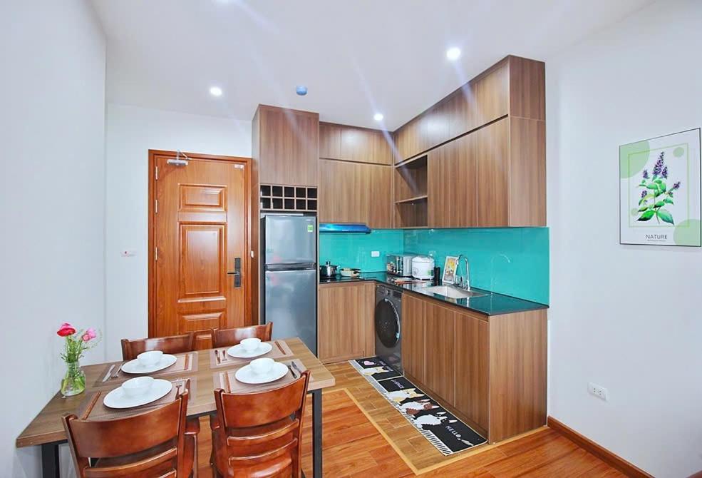 a kitchen with a table and chairs in a kitchen at An'Home Apartment Westlake in Hanoi