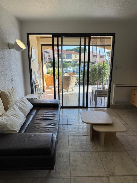 un salon avec un canapé noir et une table dans l'établissement T3 Marina tout inclus- Plage à pied, à Saint Cyprien Plage