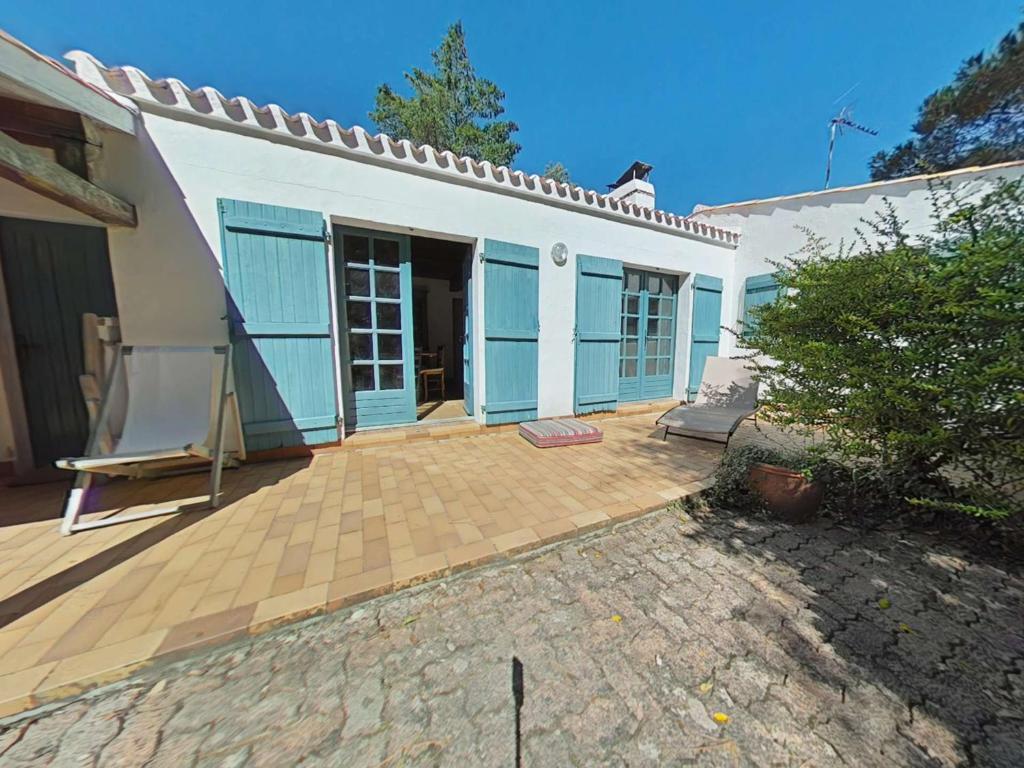 une maison blanche avec une terrasse et une maison dans l'établissement Charmante maison près de la plage avec Wi-Fi et parking privé - FR-1-224B-243, à LʼÉpine