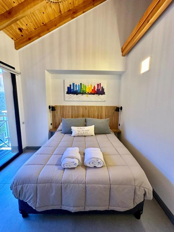 Un dormitorio con una cama grande con dos toallas encima. en Monoambiente 203B - Excelente ubicacion, en San Martín de los Andes