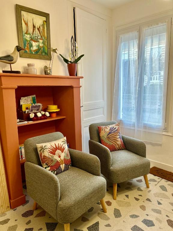 - un salon avec une chaise et une chaise dans l'établissement La maison des écoliers, à Deauville